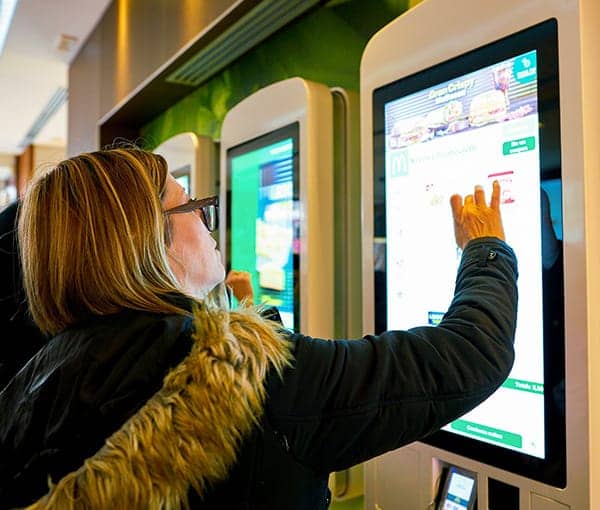 Ordering fast food from a self-order kiosk.